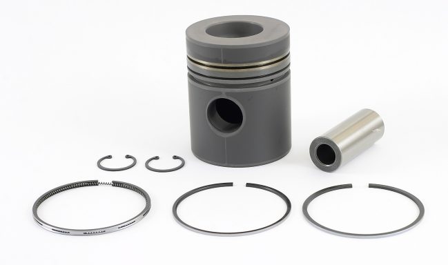 A black piston with rings and a metal cylinder fragment on a white background.
