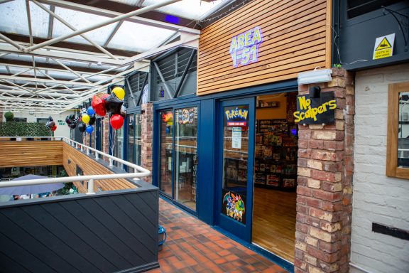 Entrance to a shop with blue doors, balloons, and a sign reading "Area 1-51".