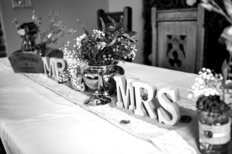Decorative table setting with "MR" and "MRS" letters and floral arrangements.