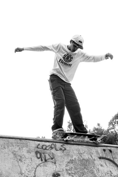 Skateboarder performing a trick on a ramp in black and white.