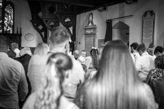 Crowd of people facing away in a church setting attending a ceremony.