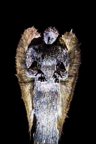 A stylised sculpture resembling an angel with prominent wings and a detailed texture.