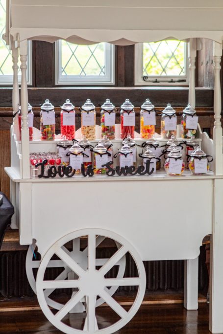 A candy cart displaying various jars of sweets with a sign reading "Too Sweet."