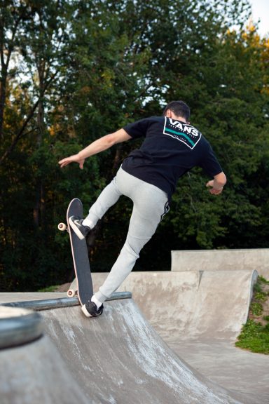 Skateboarder performing a trick on a ramp at a skatepark.