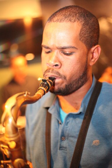 Man playing the saxophone, focused and immersed in the music.