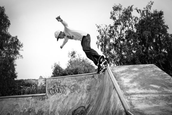 Skateboarder performing a trick on a ramp in a skate park.