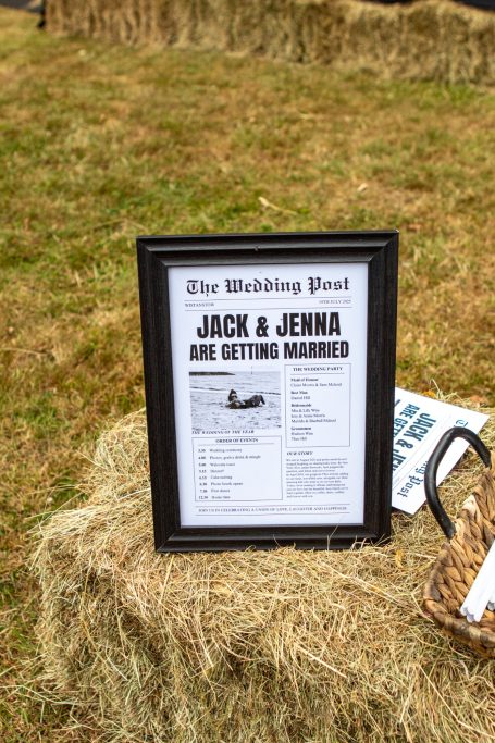 Framed wedding announcement for Jack and Jenna displayed on hay bales.