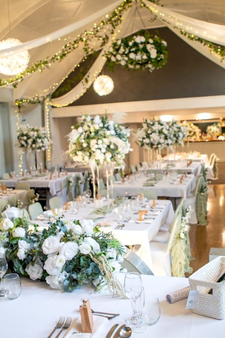 Elegant wedding reception with floral arrangements and decorated tables.