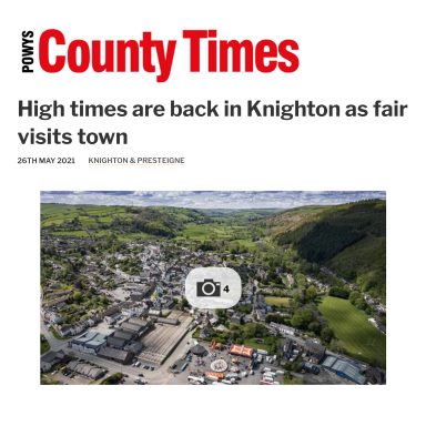 Aerial view of Knighton town with hills in the background, promoting a local fair.